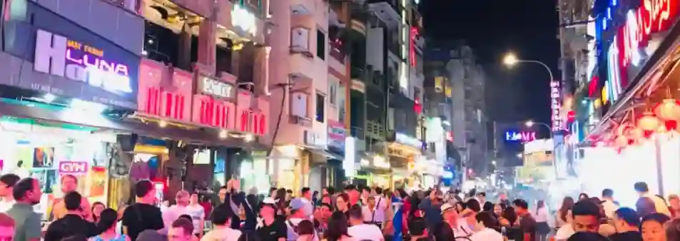 胡志明市碧文街(Bui Vien)不眠之夜，街道兩旁擠滿了在露天酒吧狂歡的人群與閃爍的雷射燈光，寫實主義攝影